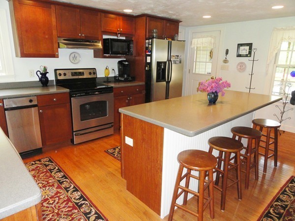 61 Coldbrook Road Oakham, MA 01068 - Photo 7 of 30 a kitchen with stainless steel appliances kitchen island granite countertop a refrigerator a stove top oven a sink with island and chairs