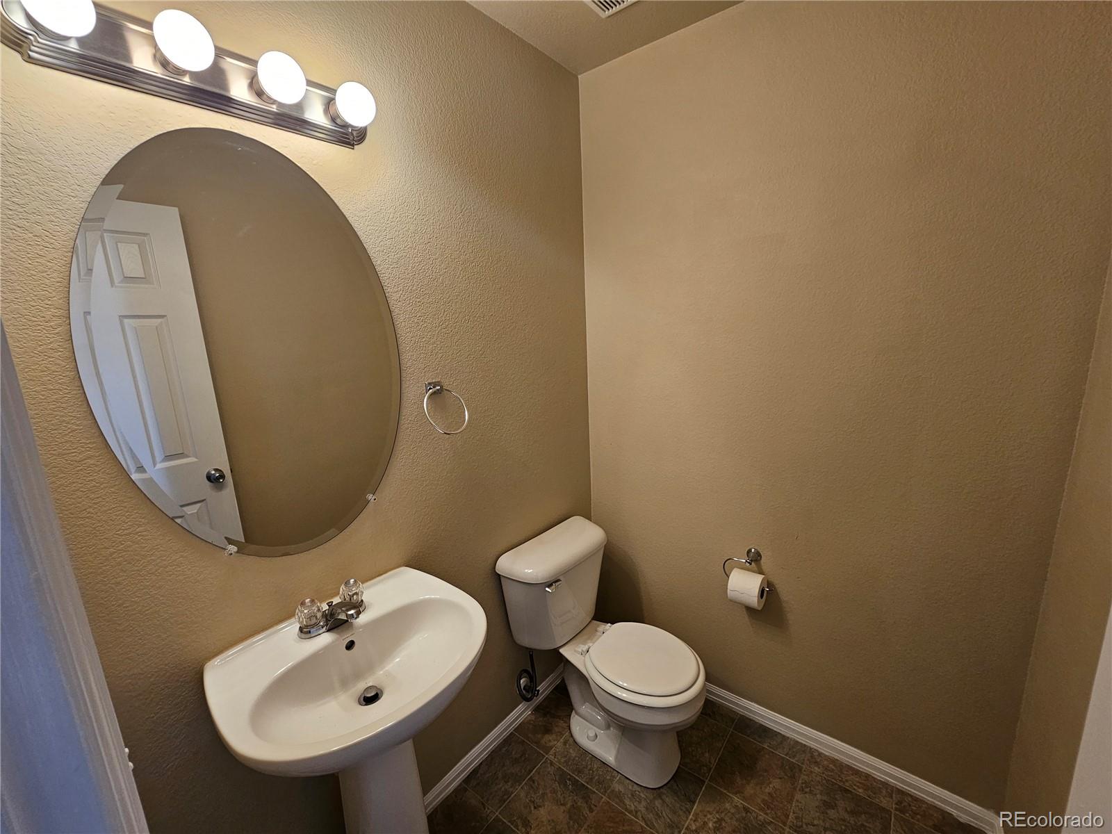 5352 Canadian Rose View Colorado Springs, CO 80916 - Photo 3 of 16 a bathroom with a toilet sink and mirror