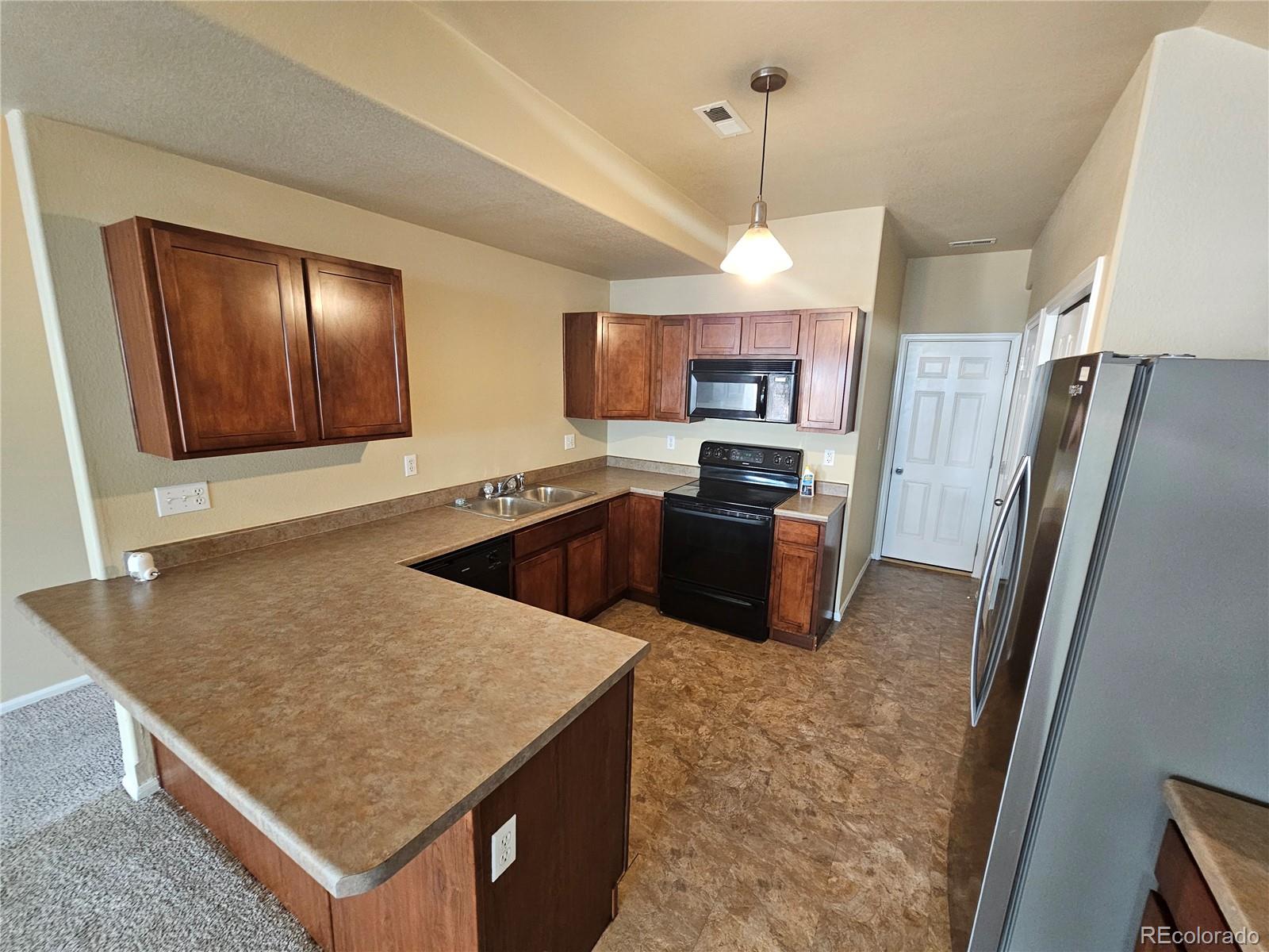 5352 Canadian Rose View Colorado Springs, CO 80916 - Photo 6 of 16 a kitchen with stainless steel appliances granite countertop a sink stove and refrigerator