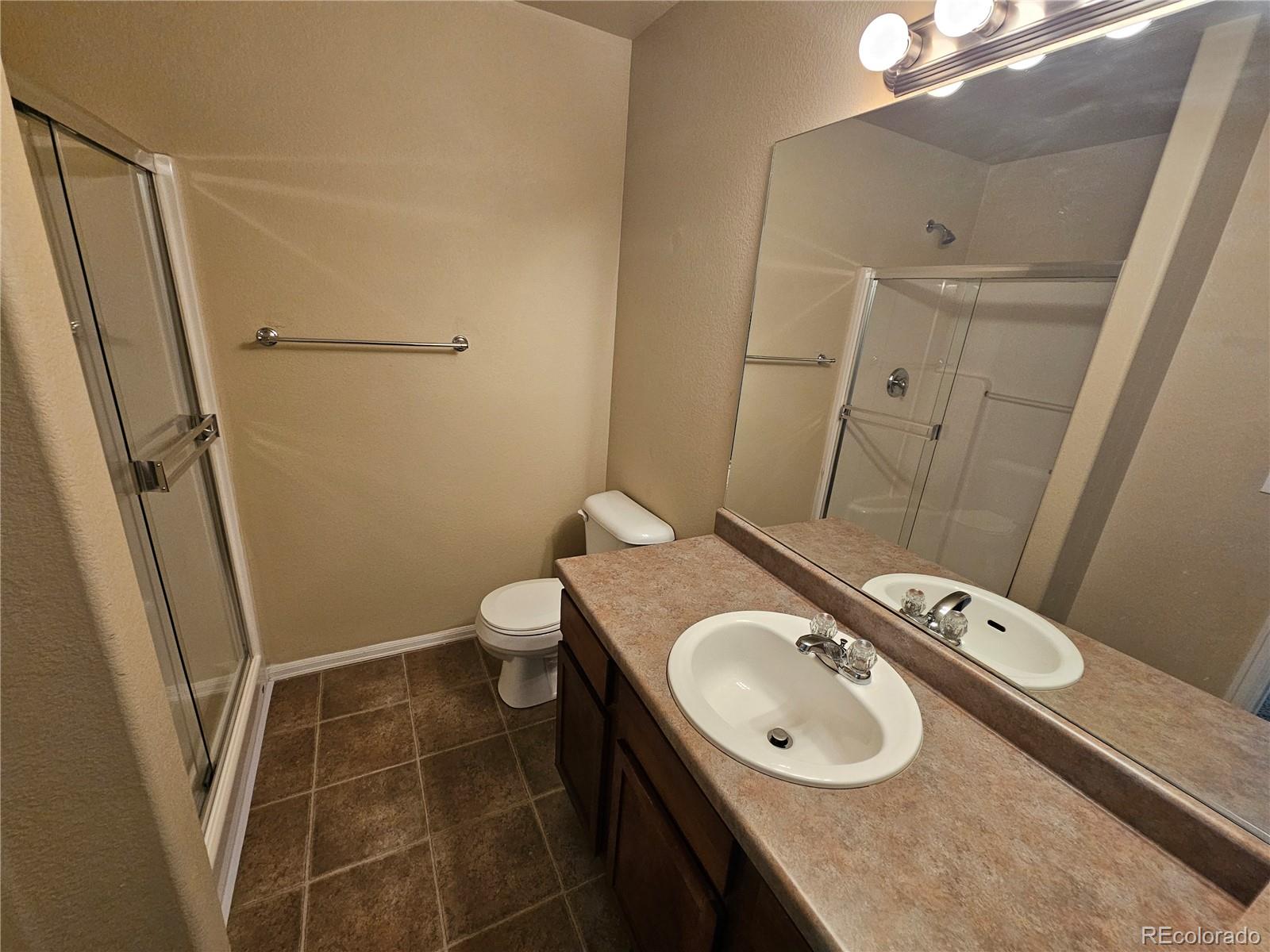 5352 Canadian Rose View Colorado Springs, CO 80916 - Photo 9 of 16 a bathroom with a sink a toilet and a mirror