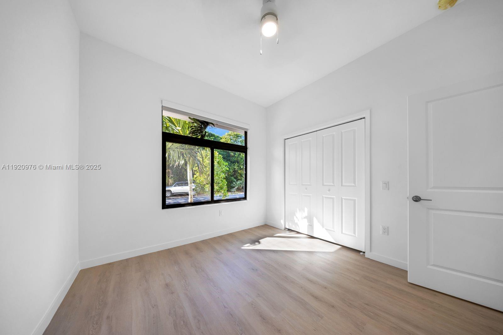 20 Northeast 19th Avenue, Unit 101 Pompano Beach, FL 33060 - Photo 8 of 17 an empty room with wooden floor and windows