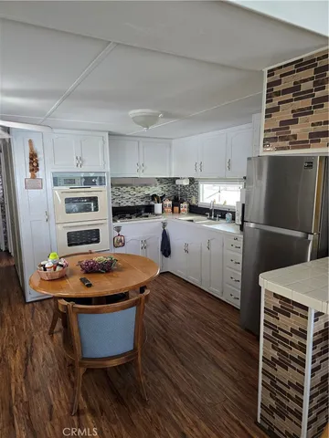 a kitchen with stainless steel appliances a stove refrigerator sink and cabinets
