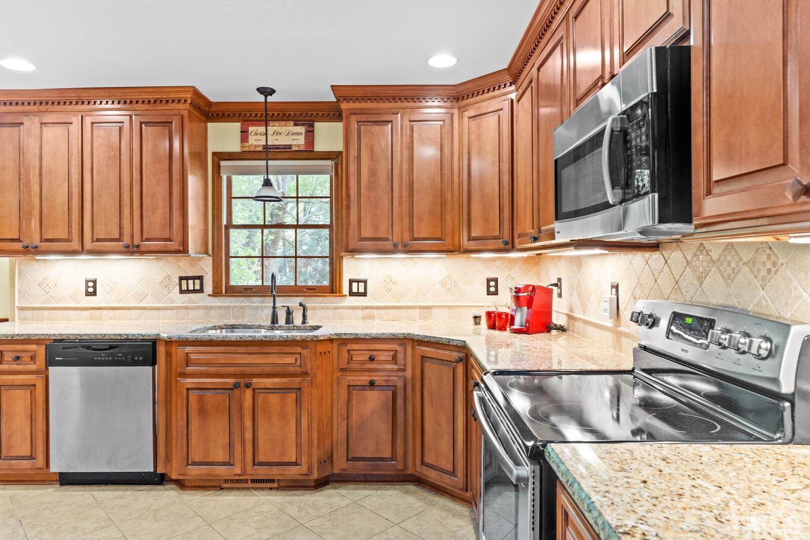 7201 Halstead Lane Raleigh, NC 27613 - Photo 11 of 38 a kitchen with stainless steel appliances granite countertop a sink stove and cabinets