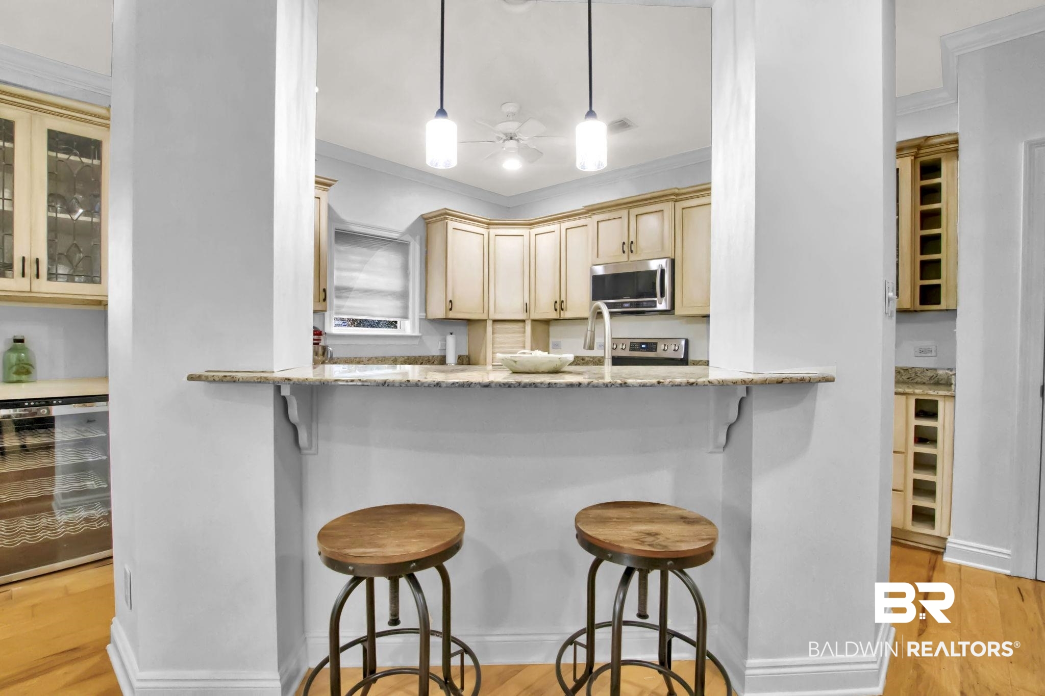 9002 Parliament Circle Daphne, AL 36526 - Photo 23 of 73 Kitchen with pendant lighting, a kitchen breakfast bar, beverage cooler, light stone counters, and light hardwood floors