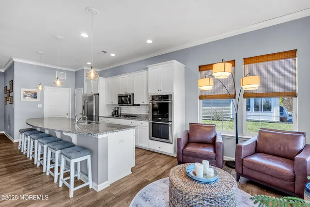 a kitchen with stainless steel appliances granite countertop a sink a stove and a refrigerator