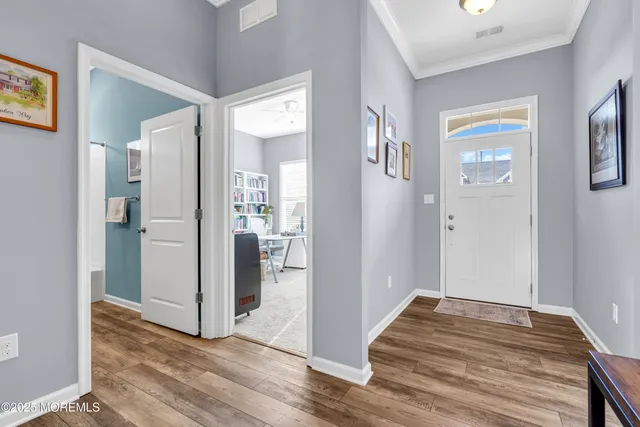 a view of a hallway with wooden floor and closet
