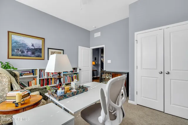 a view of a hallway with bathroom and wooden floor