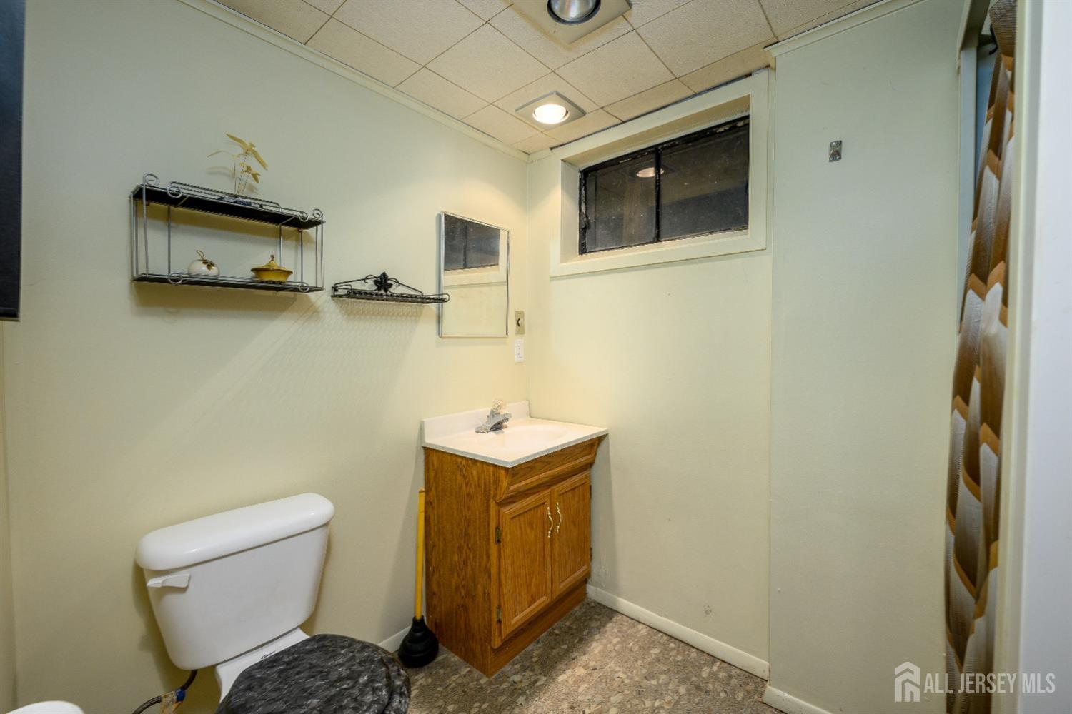 13 Brookside Road Edison, NJ 08817 - Photo 27 of 32 a bathroom with a toilet sink a mirror and shower