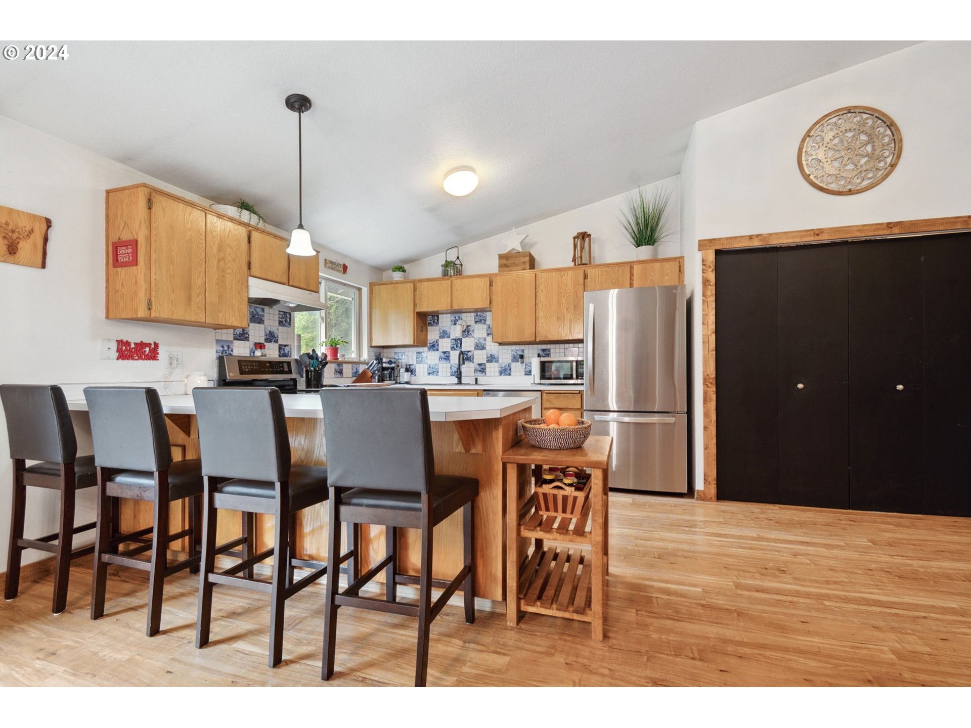 890 1st Falls View Road Stevenson, WA 98648 - Photo 14 of 43 a kitchen with stainless steel appliances kitchen island granite countertop a table chairs and a refrigerator