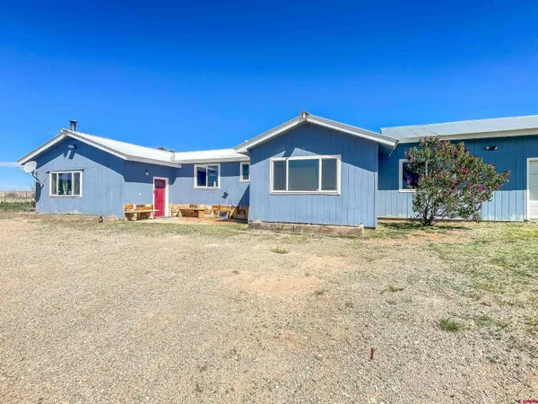 a dining room with wooden floor a chandelier a wooden table and chairs