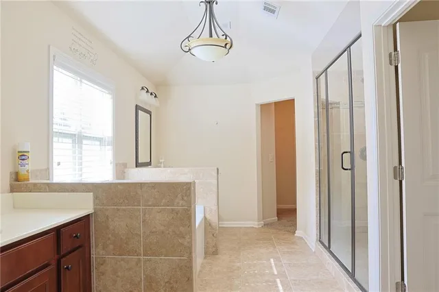 a bathroom with a granite countertop sink a mirror and a shower