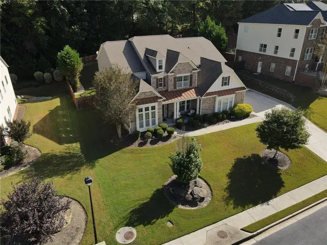 a view of a white house with a yard and potted plants