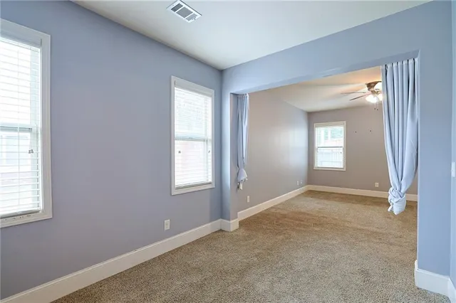 an empty room with fan and windows