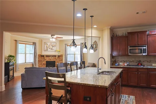 a kitchen with granite countertop a sink cabinets and living room view