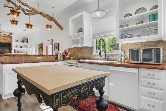 a kitchen with a sink a stove and chairs