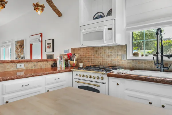 a kitchen with granite countertop white cabinets and white appliances