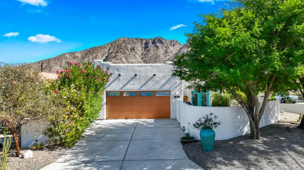 a front view of a house with a yard and tree s