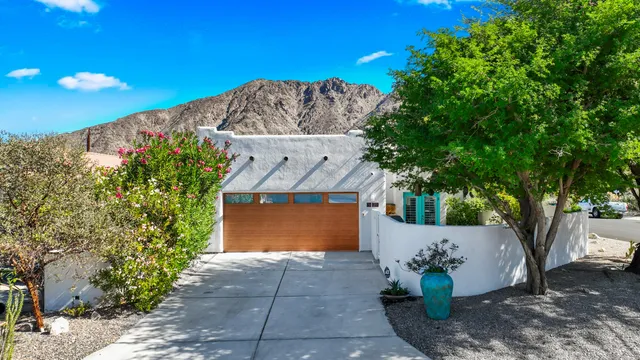 a front view of a house with a yard and tree s