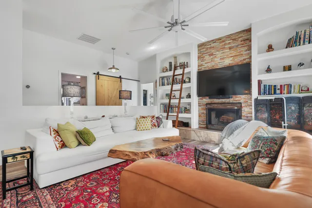a living room with furniture a flat screen tv and a fireplace