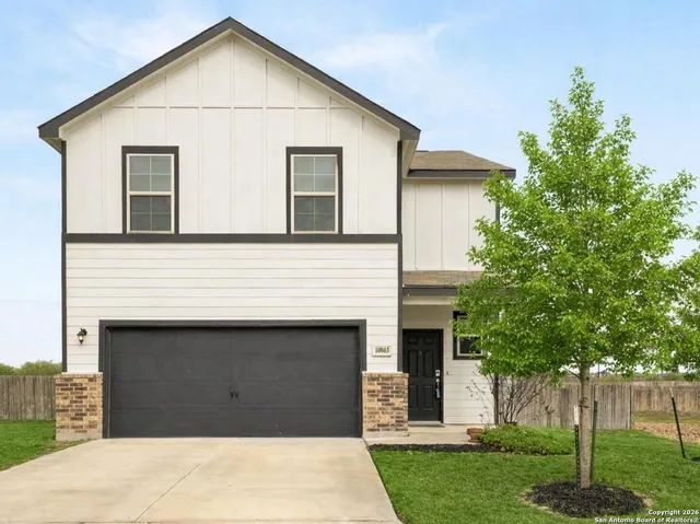 a view of a white house next to a yard