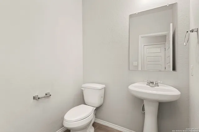 a bathroom with a sink a toilet and mirror