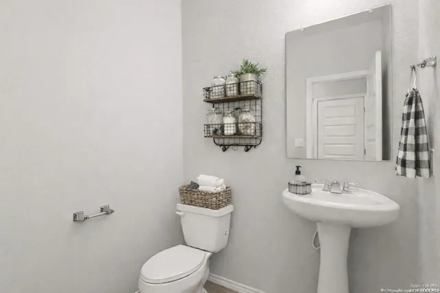 a bathroom with a sink toilet and mirror