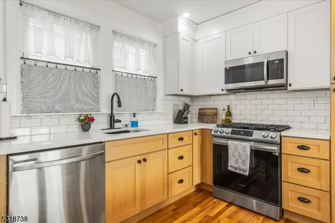 a kitchen with stainless steel appliances a stove sink and microwave