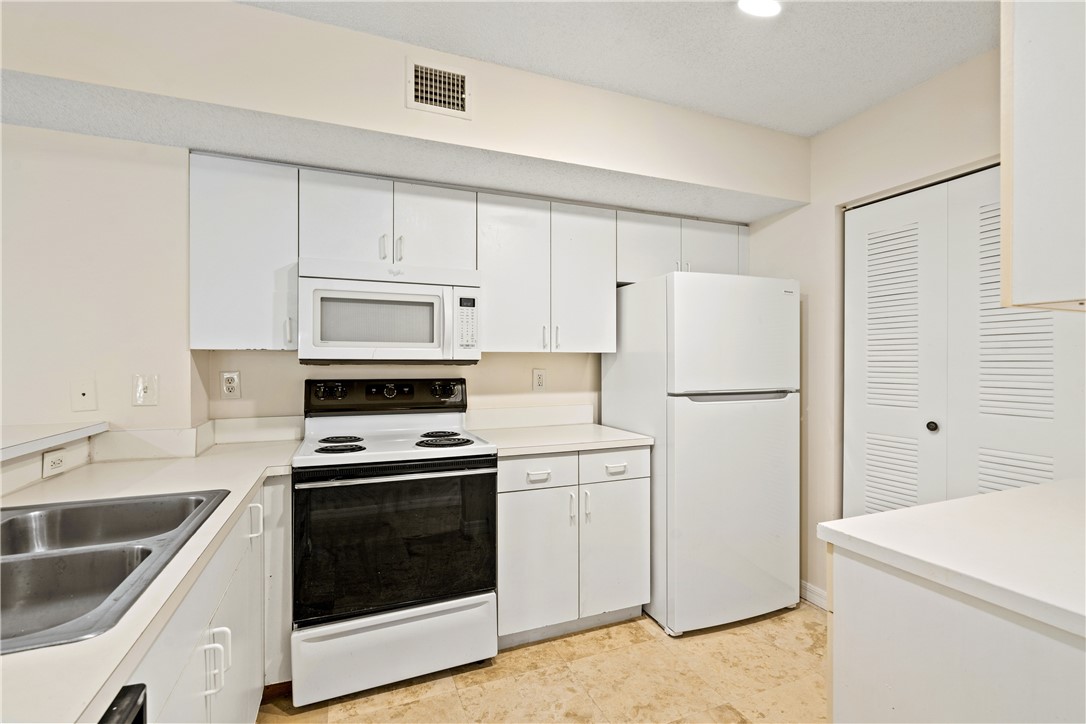 Undisclosed Address Vero Beach, FL 32967 - Photo 16 of 36 a kitchen with cabinets and white stainless steel appliances