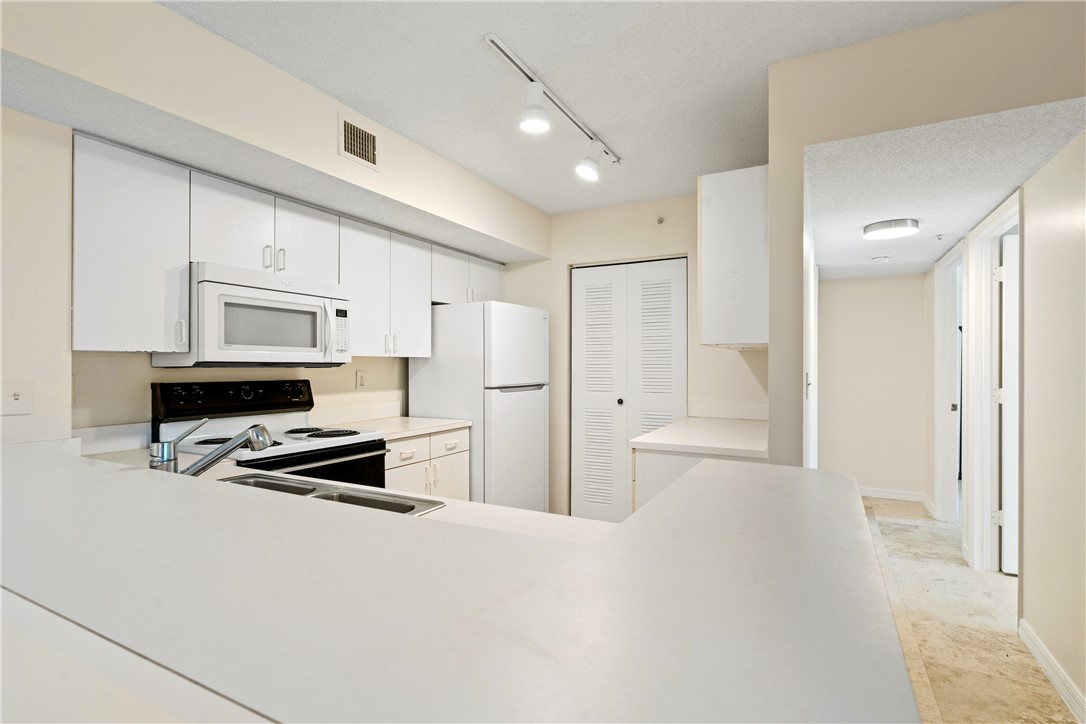 Undisclosed Address Vero Beach, FL 32967 - Photo 17 of 36 a kitchen with refrigerator cabinets and a stove top oven