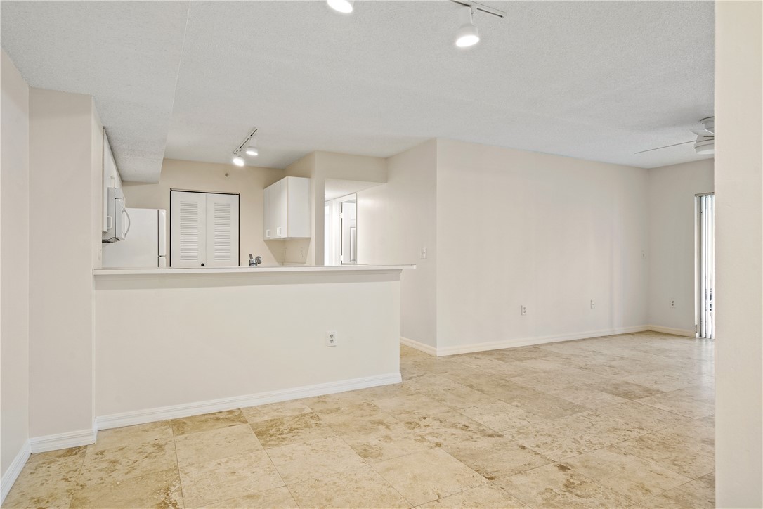 Undisclosed Address Vero Beach, FL 32967 - Photo 10 of 36 an empty room with kitchen view and wooden floor