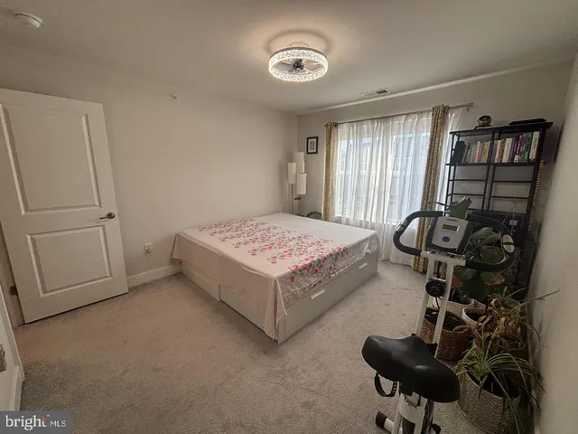 a front view of multi story building with retail shops car parked and traffic signal