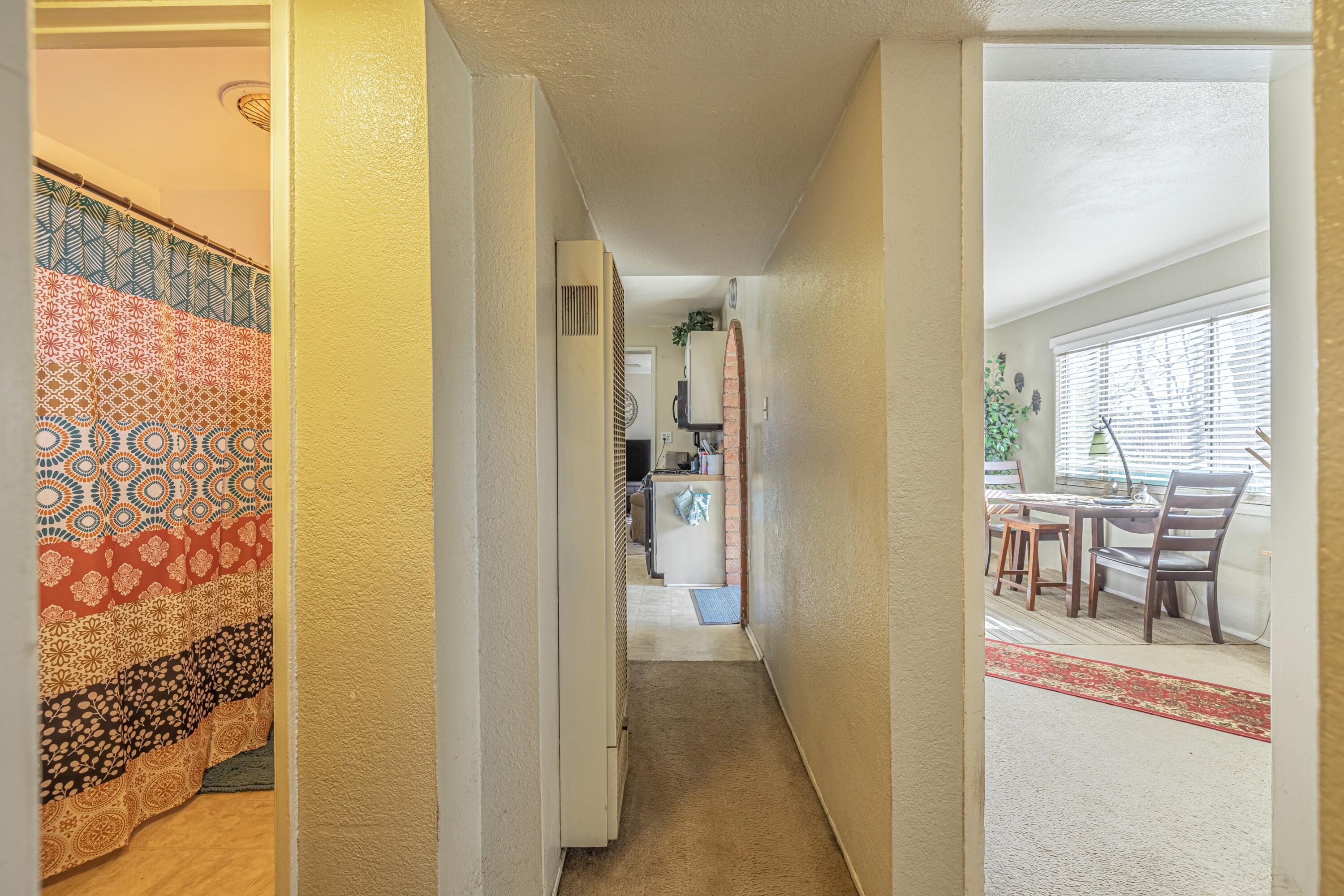 5245 West Ave L4 Lancaster, CA 93536 - Photo 18 of 35 a view of a hallway with dining area and chandelier