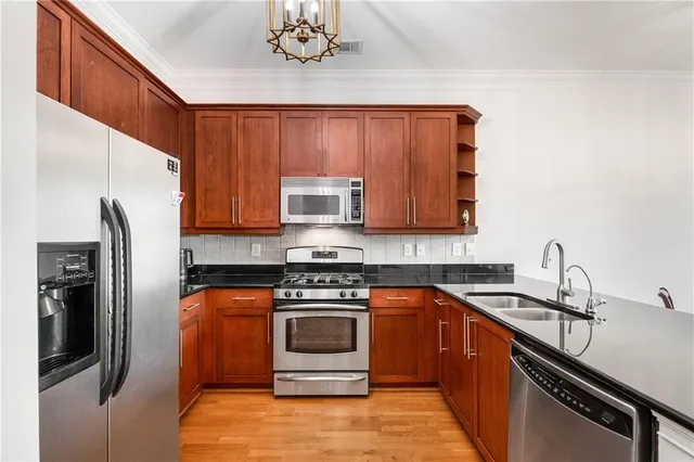 a kitchen with stainless steel appliances granite countertop a stove a sink dishwasher and a refrigerator