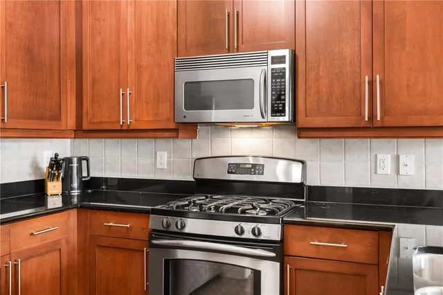 a kitchen with stainless steel appliances granite countertop a stove and a microwave