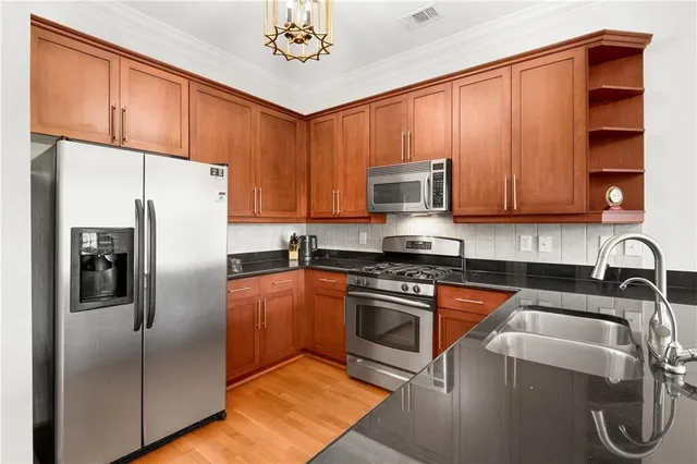 a kitchen with stainless steel appliances granite countertop a refrigerator stove top oven a sink and dishwasher