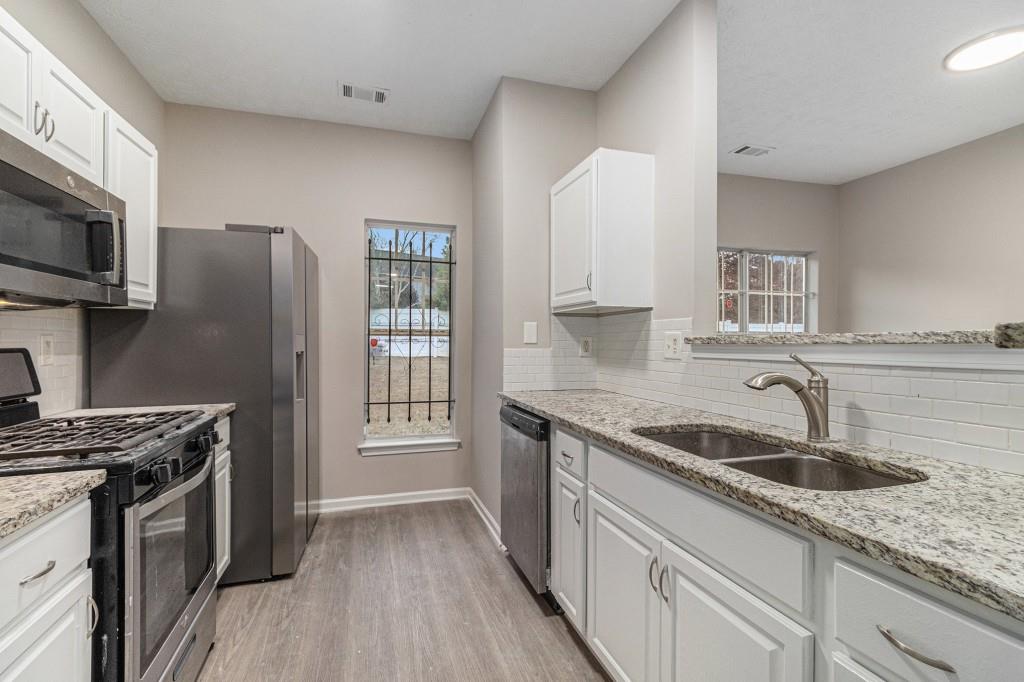 2563 Walden Lake Drive Decatur, GA 30035 - Photo 3 of 27 a kitchen with stainless steel appliances granite countertop a sink stove and refrigerator