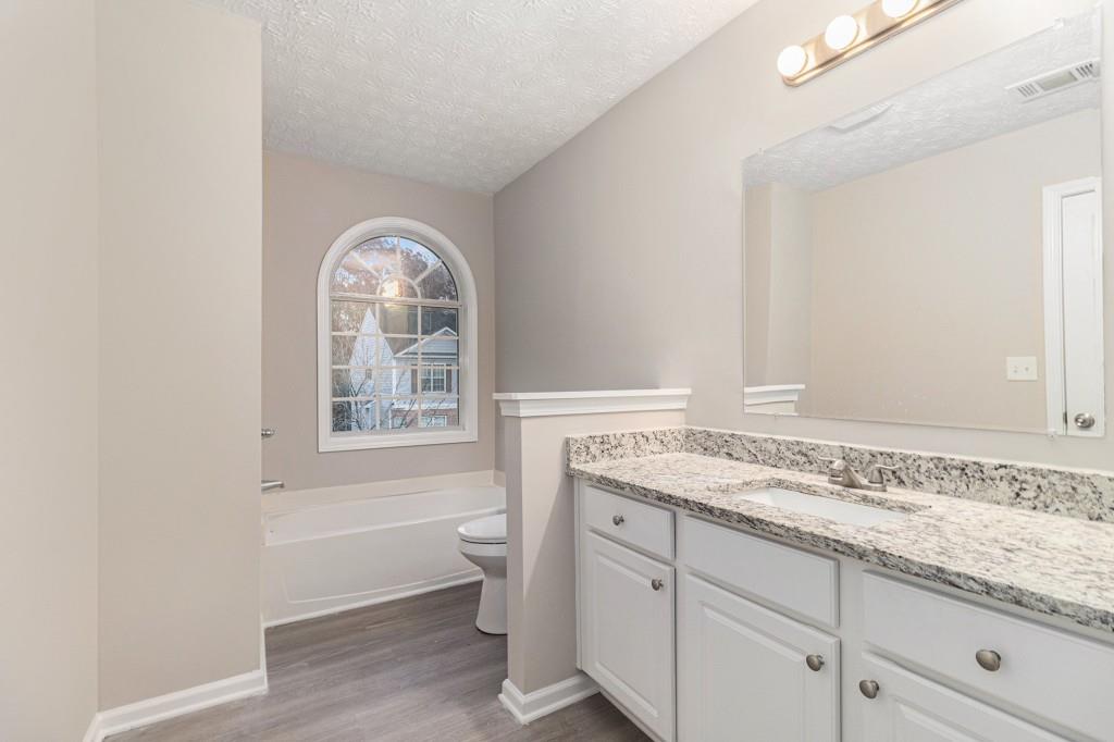 2563 Walden Lake Drive Decatur, GA 30035 - Photo 5 of 27 a bathroom with a granite countertop sink a toilet and a window