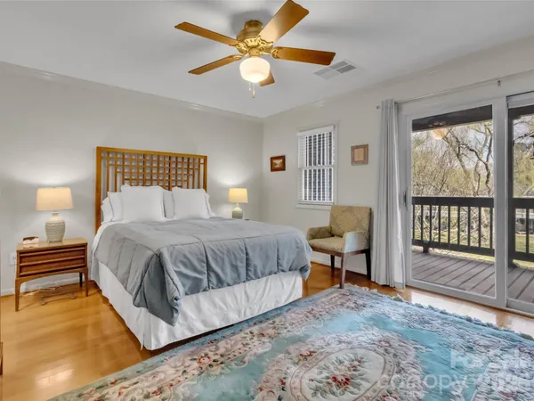 a bedroom with a large bed and a chandelier fan