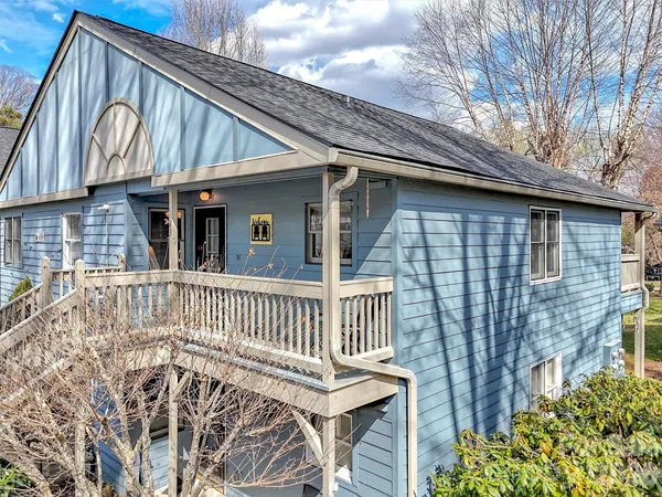 a view of a house with wooden deck and furniture