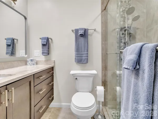 a bathroom with a granite countertop toilet sink and mirror