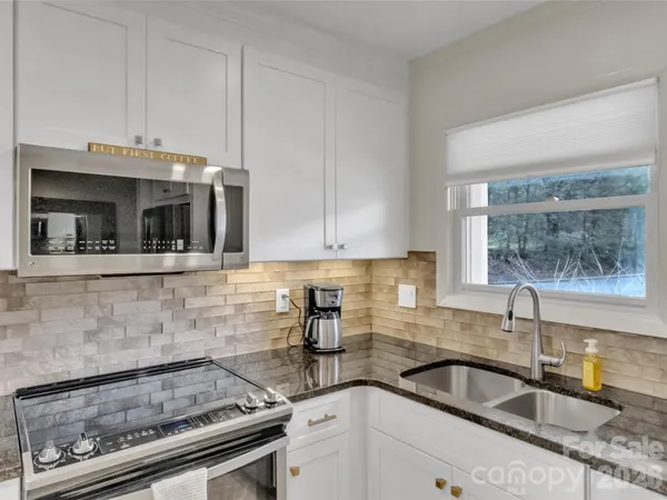 a kitchen with granite countertop a sink and cabinets