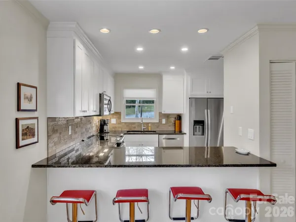 a kitchen with stainless steel appliances granite countertop a sink and refrigerator