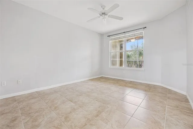 an empty room with windows and fan