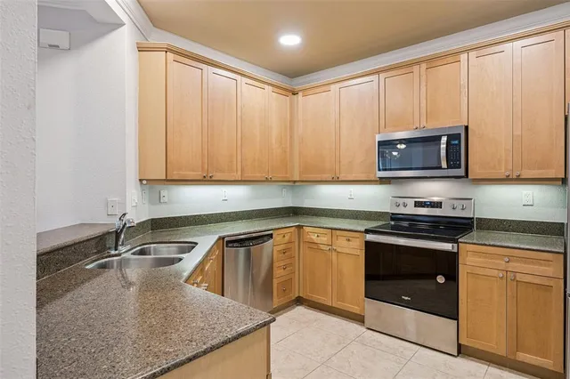 a kitchen with stainless steel appliances granite countertop a sink a stove microwave and cabinets