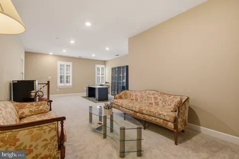 a living room with furniture a large window and wooden floor