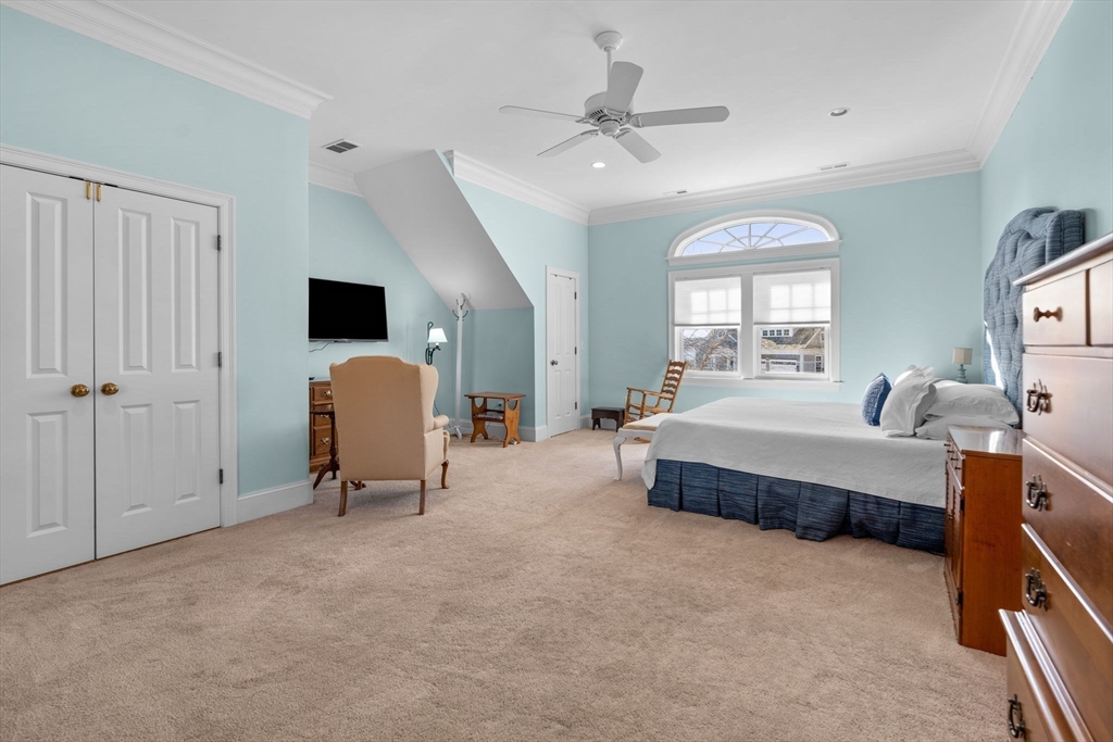 67 Uncle Alberts Drive Chatham, MA 02633 - Photo 30 of 41 a spacious bedroom with a bed and a chandelier