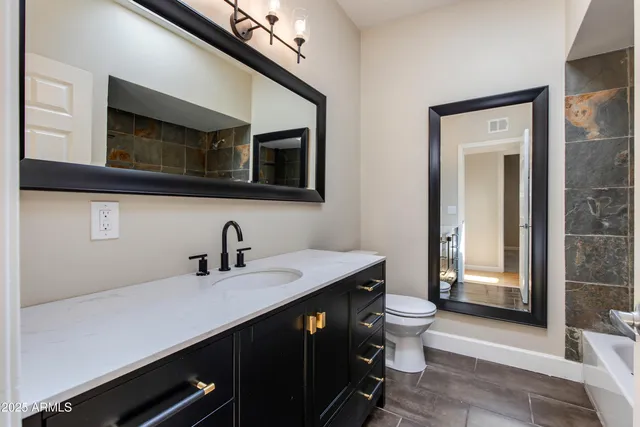 a bathroom with a sink a toilet and mirror