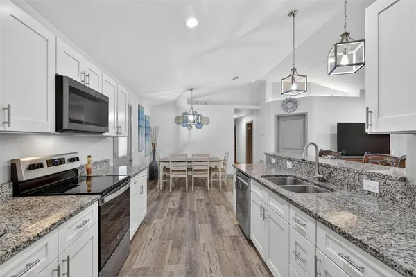a kitchen with stainless steel appliances granite countertop a sink stove and refrigerator