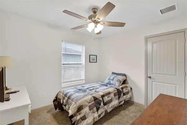 a bedroom with a large bed and a chandelier