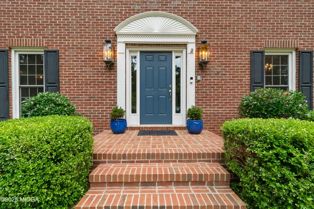 a dining room with furniture a chandelier and wooden floor